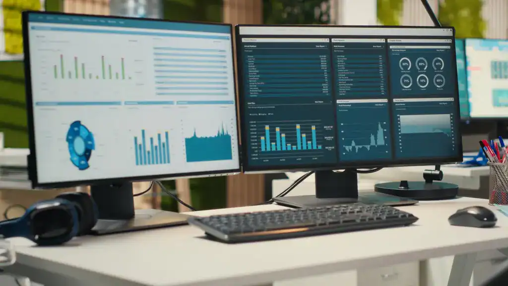 Business intelligence dashboards displayed across dual computer monitors