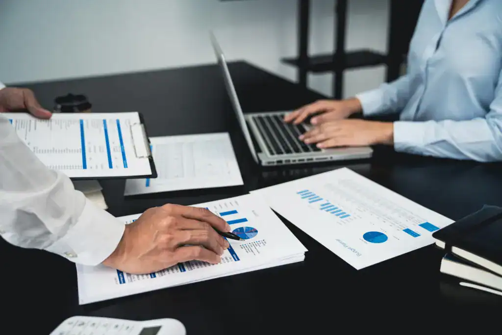 Professionals reviewing business reports, charts, and performance data during a meeting