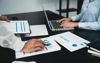 Professionals reviewing business reports, charts, and performance data during a meeting