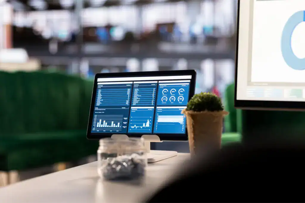 Digital dashboard displaying business performance charts and metrics in an office